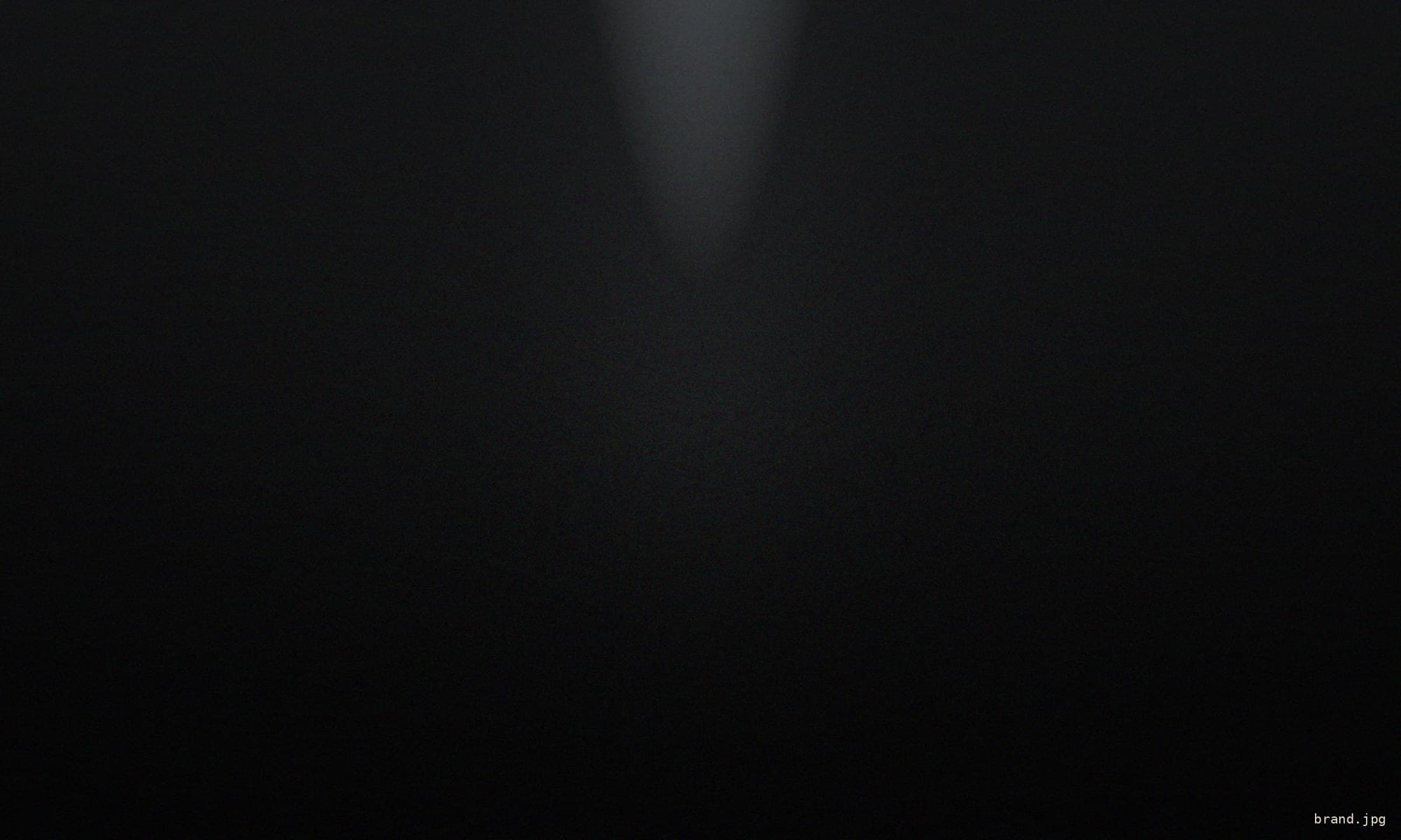 A lone figure standing in a shaft of light within a dark cathedral
